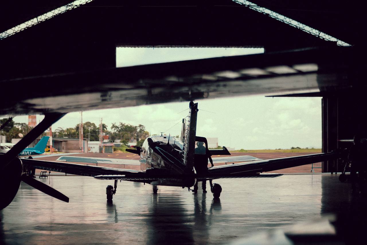 Vista de dentro do hangar para o pátio e a pista
