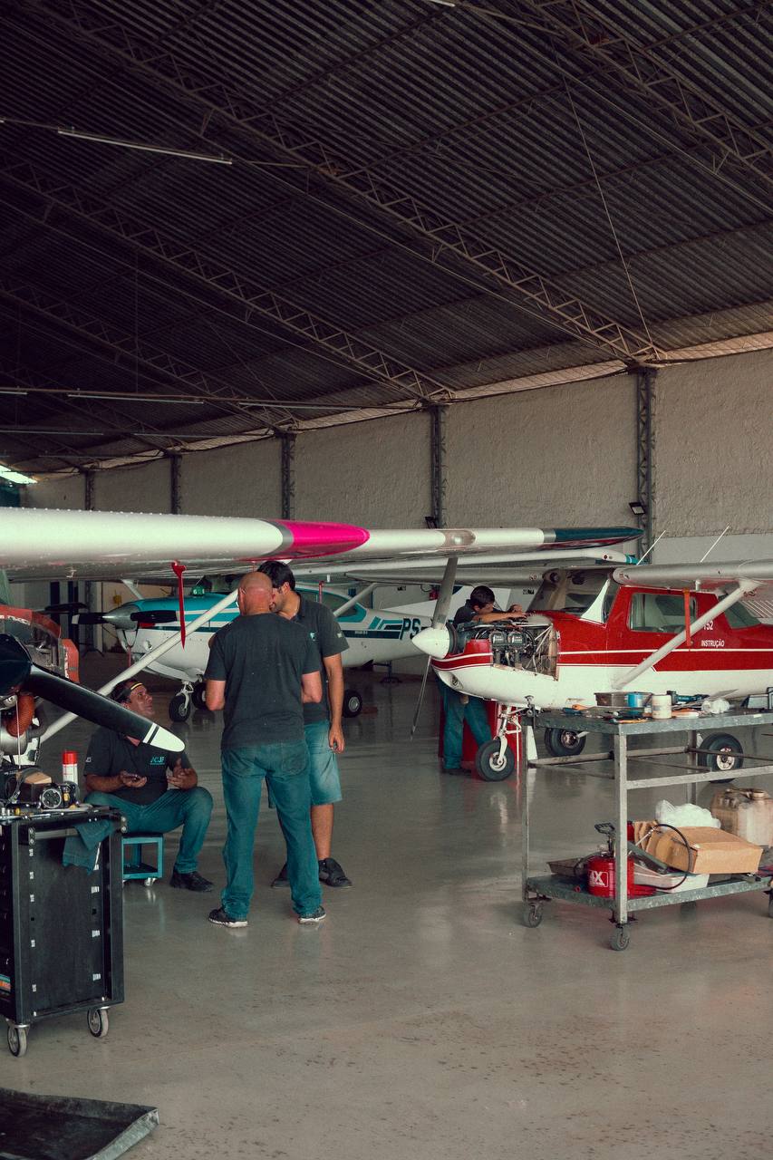 Mecânicos trabalhando em aeronaves dentro do hangar de manutenção