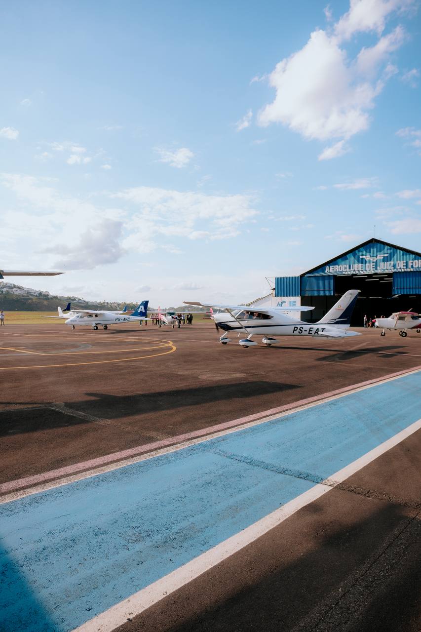 Aeronaves estacionadas no pátio do Aeroclube com o hangar ao fundo