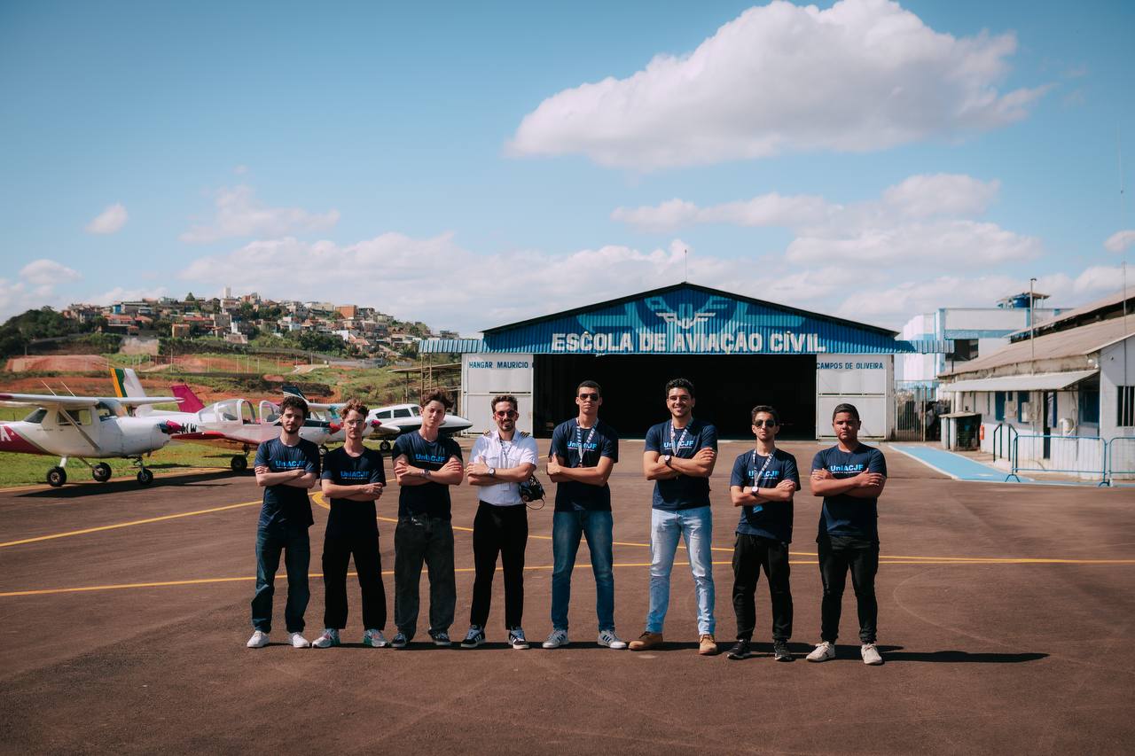 Turma de alunos e instrutor em frente ao hangar da Escola de Aviação Civil