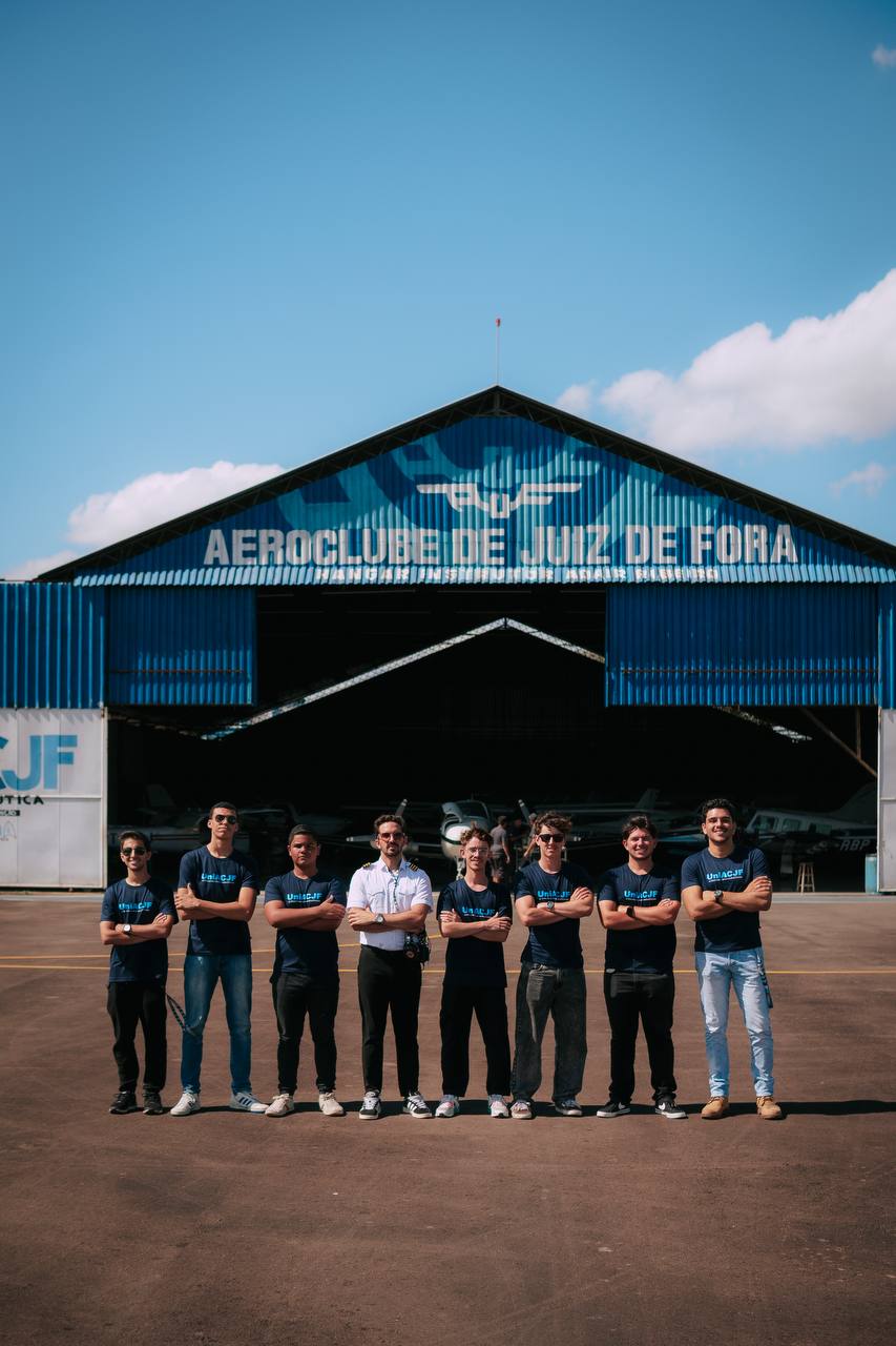 Alunos e instrutor enfileirados em frente ao hangar do Aeroclube de Juiz de Fora